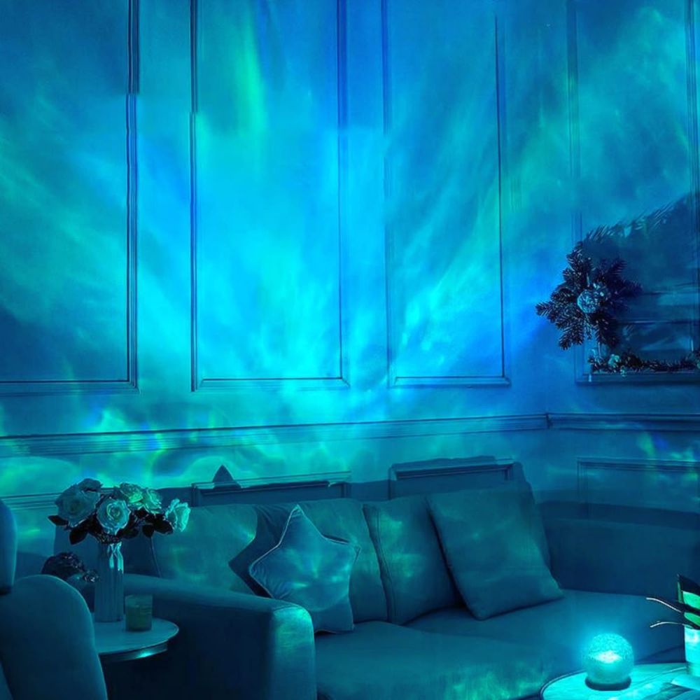 Living room with blue light projection on the wall, featuring a sofa and decorative items.